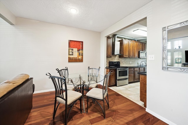 1018 Memorial Village Dr Unit 124, Houston, TX 77024 - dining room featuring light wood-style flooring and a textured ceiling