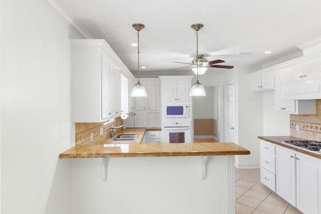 1418 Louisiana Ave, Pasadena, TX 77536 - kitchen featuring white appliances, backsplash, ceiling fan, a peninsula, and light tile patterned flooring