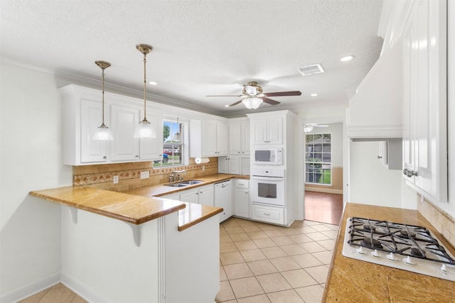1418 Louisiana Ave, Pasadena, TX 77536 - kitchen with white appliances, a peninsula, white cabinetry, ceiling fan, and ornamental molding