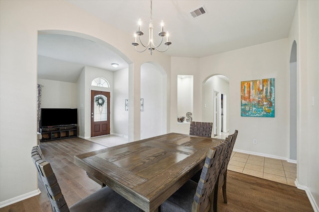 9111 Kinnel Ln, Tomball, TX 77375 - dining area featuring a chandelier, wood finished floors, and arched walkways