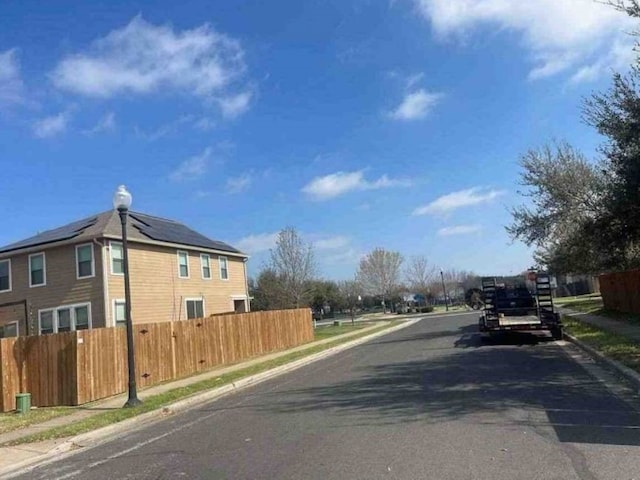 5608 Nijmegen Dr, Del Valle, TX 78617 - view of asphalt road featuring sidewalks, curbs, and street lights
