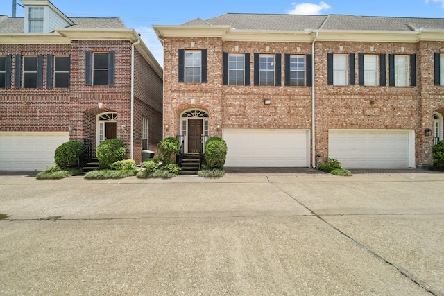 1931 Woodbury St, Houston, TX 77030 - view of front of home with an attached garage, driveway, brick siding, and roof with shingles