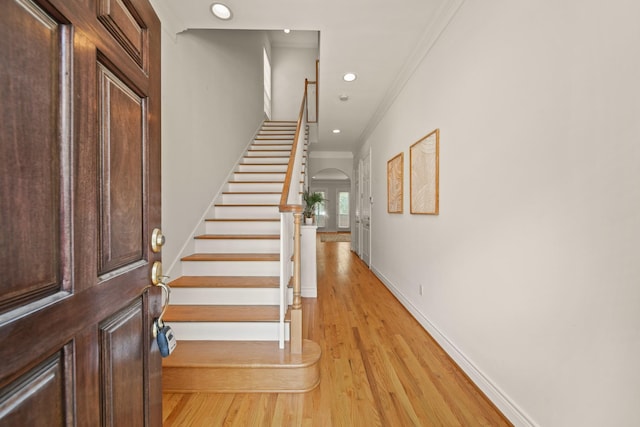 1931 Woodbury St, Houston, TX 77030 - entryway with ornamental molding, stairs, light wood finished floors, arched walkways, and recessed lighting