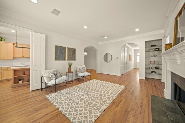 1931 Woodbury St, Houston, TX 77030 - sitting room with arched walkways, light wood finished floors, a fireplace with flush hearth, recessed lighting, and built in features