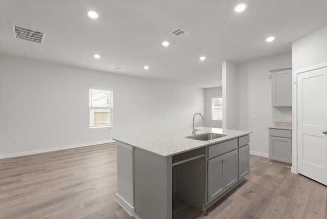 436 Shoreview Dr, Conroe, TX 77303 - kitchen with gray cabinetry, healthy amount of natural light, an island with sink, light wood-style floors, and recessed lighting