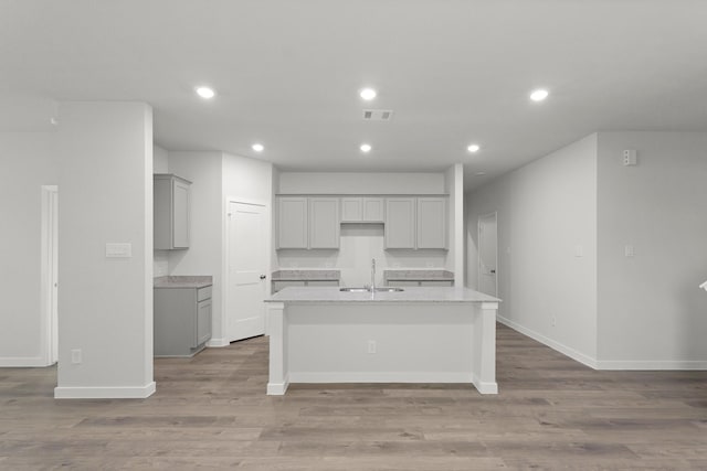 436 Shoreview Dr, Conroe, TX 77303 - kitchen with gray cabinets, a kitchen island with sink, recessed lighting, light countertops, and light wood-style flooring