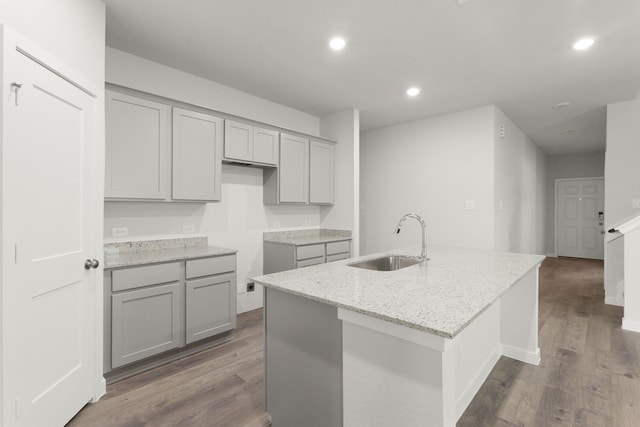436 Shoreview Dr, Conroe, TX 77303 - kitchen with gray cabinetry, light stone counters, dark wood finished floors, recessed lighting, and an island with sink