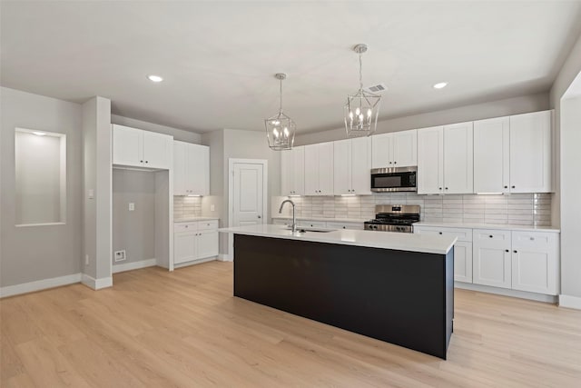 2845 14th St, Hempstead, TX 77445 - kitchen with appliances with stainless steel finishes, decorative backsplash, a chandelier, white cabinets, and recessed lighting