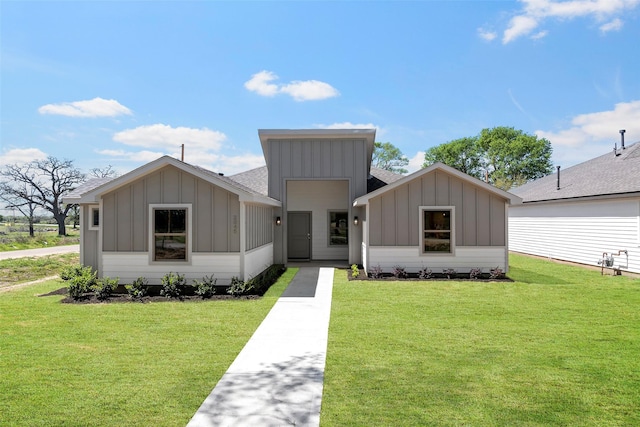 2845 14th St, Hempstead, TX 77445 - view of front facade featuring board and batten siding, a front lawn, and a shingled roof