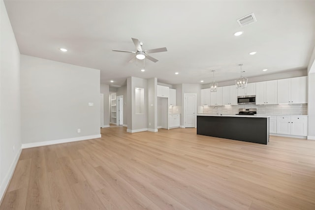 2845 14th St, Hempstead, TX 77445 - kitchen with stainless steel microwave, ceiling fan, range, tasteful backsplash, and recessed lighting