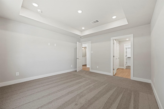 2845 14th St, Hempstead, TX 77445 - unfurnished bedroom with a tray ceiling, recessed lighting, light colored carpet, and connected bathroom
