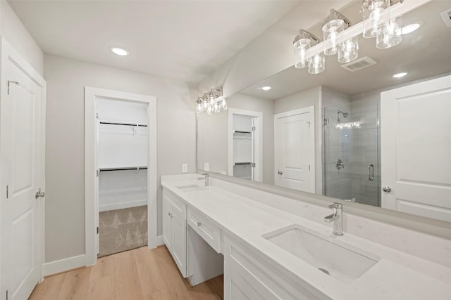 2845 14th St, Hempstead, TX 77445 - full bathroom with a spacious closet, a stall shower, double vanity, wood finished floors, and recessed lighting