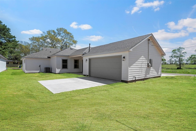 2845 14th St, Hempstead, TX 77445 - rear view of house with an attached garage, driveway, a shingled roof, and a lawn