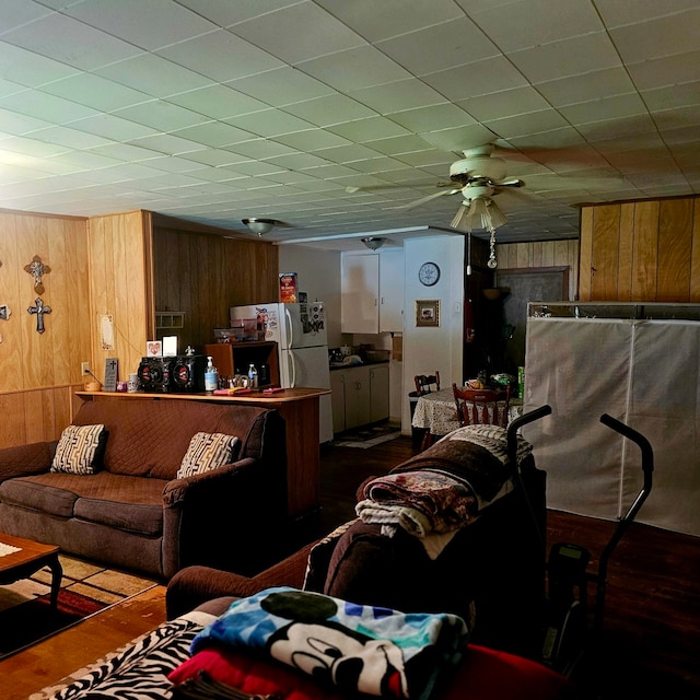 710 College St, El Campo, TX 77437 - living area with wood walls, wood finished floors, and ceiling fan