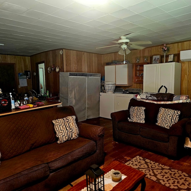 710 College St, El Campo, TX 77437 - living room with wooden walls, ceiling fan, dark wood finished floors, a wall mounted air conditioner, and independent washer and dryer