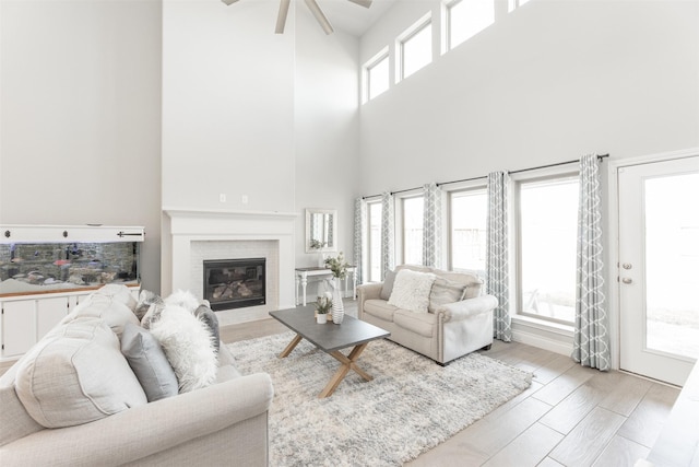 13746 Brahman Valley Ct, Cypress, TX 77429 - living area with a towering ceiling, wood finished floors, a ceiling fan, and a fireplace