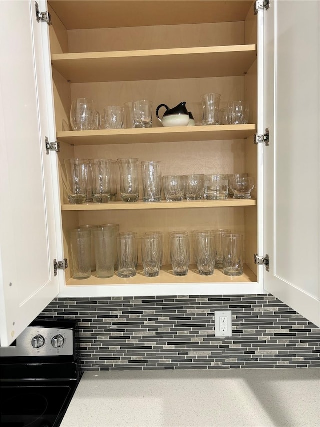 4739 Reed Rd Unit A, Houston, TX 77033 - kitchen view of black electric range oven, backsplash, white cabinetry, and open shelves