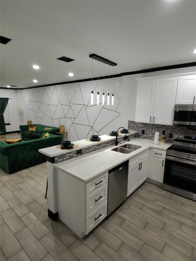 4739 Reed Rd Unit A, Houston, TX 77033 - kitchen featuring stainless steel appliances, decorative backsplash, a peninsula, white cabinets, and recessed lighting