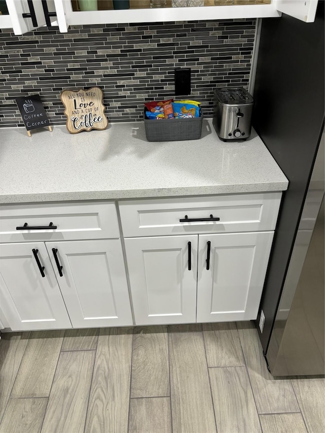 4739 Reed Rd Unit A, Houston, TX 77033 - detailed view of backsplash, wood finished floors, and freestanding refrigerator