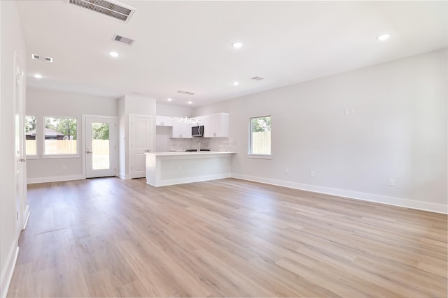 6909 S Hall St, Houston, TX 77028 - unfurnished living room with light wood-style flooring and recessed lighting