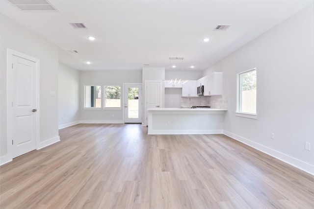 6909 S Hall St, Houston, TX 77028 - unfurnished living room featuring healthy amount of natural light, light wood-style flooring, and recessed lighting