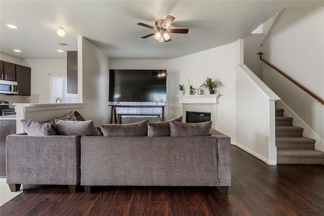 20507 Avery Grove Ct, Cypress, TX 77433 - living area with a ceiling fan, dark wood-type flooring, stairway, a tile fireplace, and recessed lighting