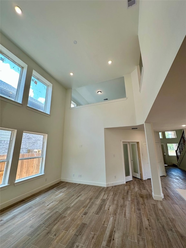 16446 Elk Meadow Dr, Conroe, TX 77302 - unfurnished living room with a high ceiling, wood finished floors, stairs, and recessed lighting