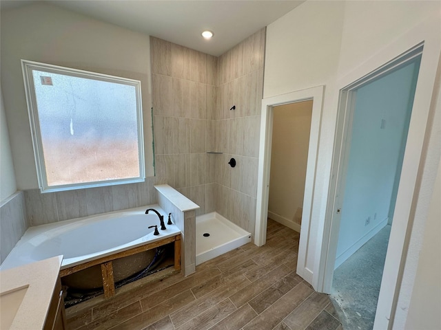 16446 Elk Meadow Dr, Conroe, TX 77302 - full bathroom featuring a garden tub, a tile shower, and wood finished floors