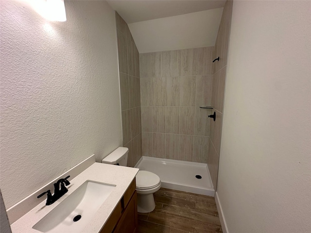 16446 Elk Meadow Dr, Conroe, TX 77302 - bathroom with tiled shower, wood finished floors, a textured wall, and vanity