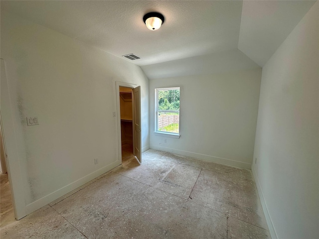 16446 Elk Meadow Dr, Conroe, TX 77302 - unfurnished bedroom with a walk in closet and a textured ceiling