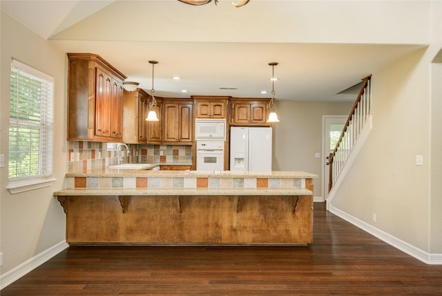 238 Horse Shoe Trl, Angleton, TX 77515 - kitchen featuring white appliances, a peninsula, dark wood-style floors, brown cabinets, and recessed lighting