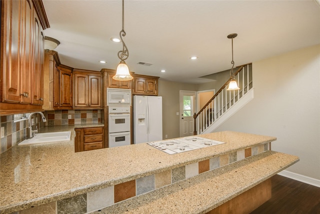 238 Horse Shoe Trl, Angleton, TX 77515 - kitchen with white appliances, dark wood-type flooring, light stone countertops, decorative backsplash, and brown cabinets