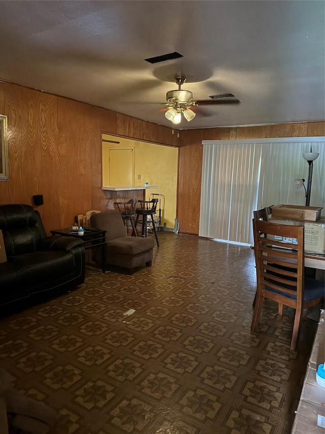 4830 Teton St, Houston, TX 77033 - living area with wood walls, ceiling fan, and dark flooring