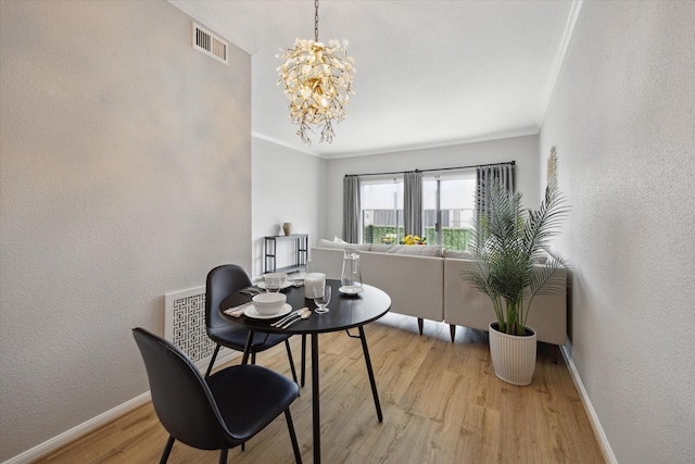 2475 Underwood St Unit 369, Houston, TX 77030 - dining space featuring light wood-type flooring, a textured wall, a chandelier, and crown molding