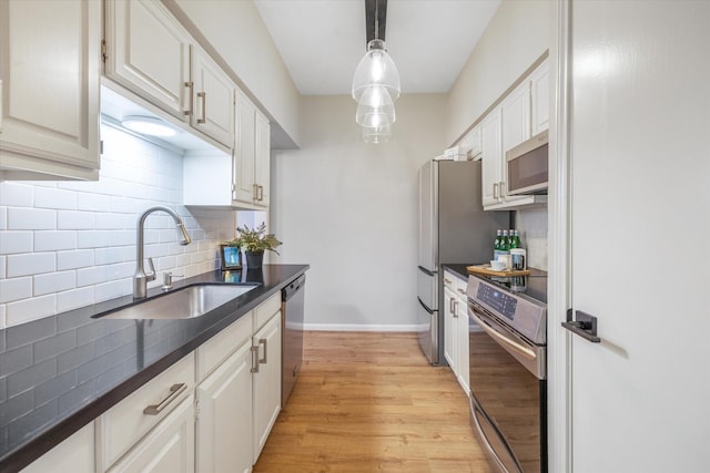 2475 Underwood St Unit 369, Houston, TX 77030 - kitchen with stainless steel appliances, dark countertops, backsplash, light wood-type flooring, and pendant lighting