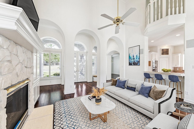 966 Bentwater Dr, Montgomery, TX 77356 - living area with a towering ceiling, ceiling fan, wood-type flooring, a glass covered fireplace, and arched walkways
