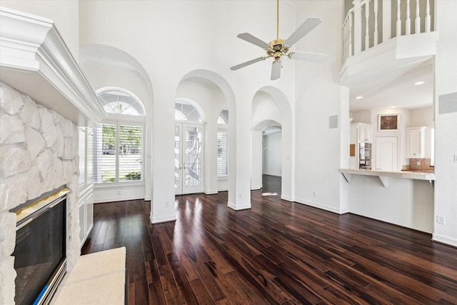 966 Bentwater Dr, Montgomery, TX 77356 - unfurnished living room featuring a towering ceiling, wood finished floors, ceiling fan, and a stone fireplace
