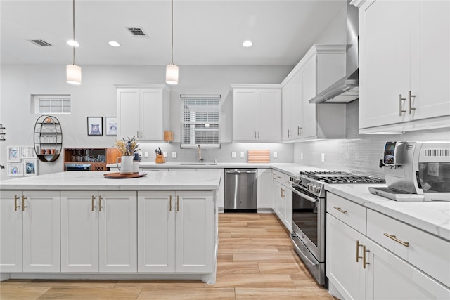 344 W 27th St, Houston, TX 77008 - kitchen featuring stainless steel appliances, wall chimney exhaust hood, white cabinets, recessed lighting, and backsplash