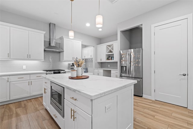 344 W 27th St, Houston, TX 77008 - kitchen with stainless steel appliances, wall chimney range hood, a center island, white cabinets, and light wood finished floors