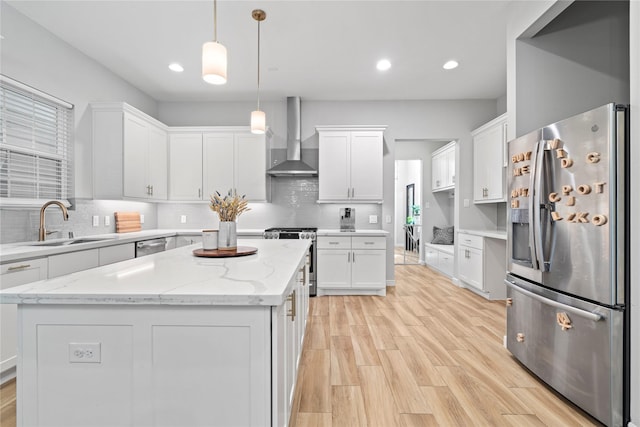 344 W 27th St, Houston, TX 77008 - kitchen featuring appliances with stainless steel finishes, wall chimney exhaust hood, light wood-style flooring, white cabinets, and recessed lighting