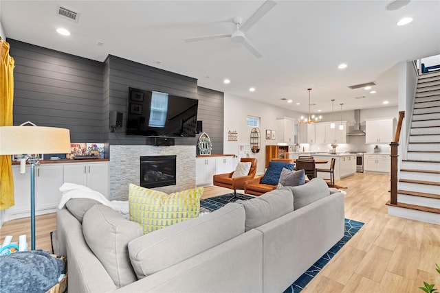 344 W 27th St, Houston, TX 77008 - living room with stairway, ceiling fan, wooden walls, a glass covered fireplace, and recessed lighting