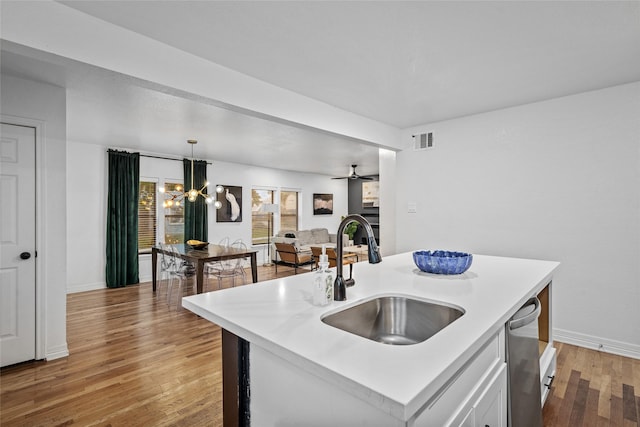 3404 Rosedale St, Houston, TX 77004 - kitchen with light countertops, light wood finished floors, white cabinets, and pendant lighting