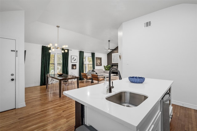3404 Rosedale St, Houston, TX 77004 - kitchen with lofted ceiling, light wood-type flooring, light countertops, a fireplace, and a chandelier