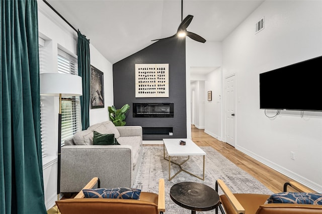 3404 Rosedale St, Houston, TX 77004 - living area featuring a glass covered fireplace, vaulted ceiling, wood finished floors, and a ceiling fan