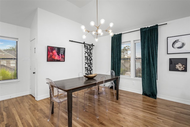 3404 Rosedale St, Houston, TX 77004 - dining room featuring a barn door, a chandelier, wood finished floors, and healthy amount of natural light
