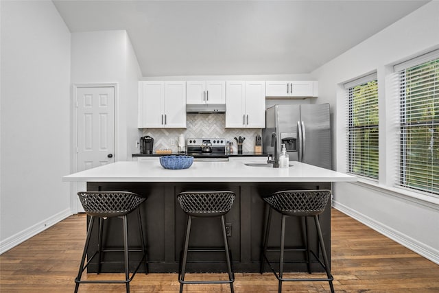 3404 Rosedale St, Houston, TX 77004 - kitchen featuring appliances with stainless steel finishes, under cabinet range hood, white cabinets, and an island with sink