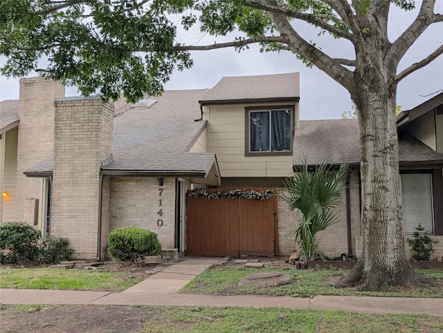 7140 S Dairy Ashford Rd, Houston, TX 77072 - view of front of home featuring brick siding, roof with shingles, and a chimney