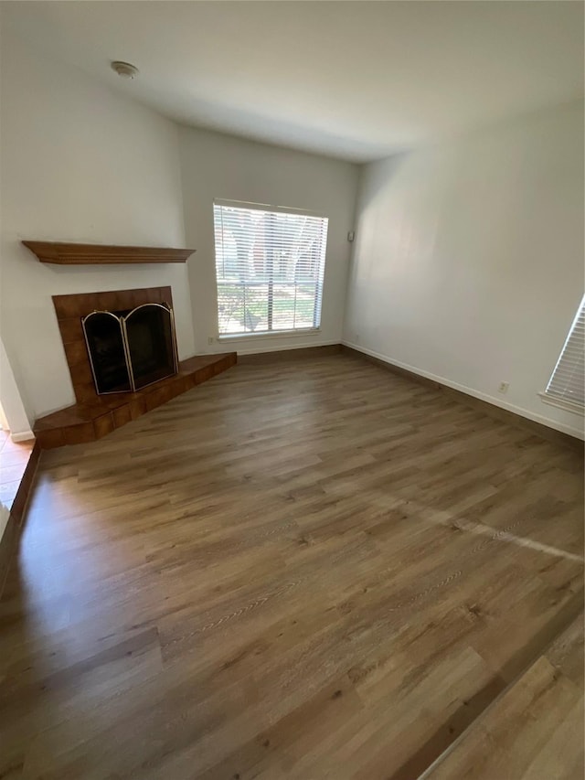 3100 Walnut Bend Ln Unit 113, Houston, TX 77042 - unfurnished living room with wood finished floors and a fireplace with raised hearth