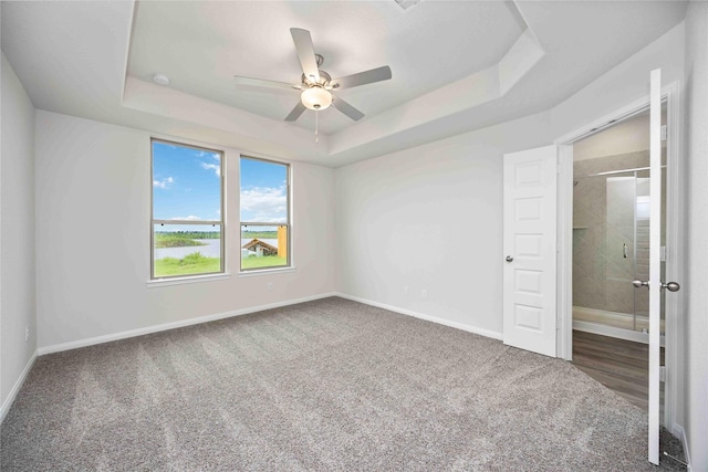 16853 Needlepoint Dr, Conroe, TX 77302 - unfurnished bedroom featuring a tray ceiling, carpet floors, and a ceiling fan