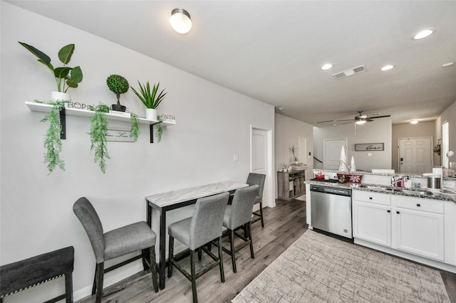 3923 Calasso Ct, Katy, TX 77493 - kitchen featuring stainless steel dishwasher, light wood-type flooring, white cabinets, ceiling fan, and recessed lighting